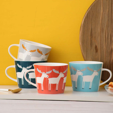 Colorful ceramic mugs with Nordic animal design on a wooden table, ideal for coffee, tea, or hot beverages.